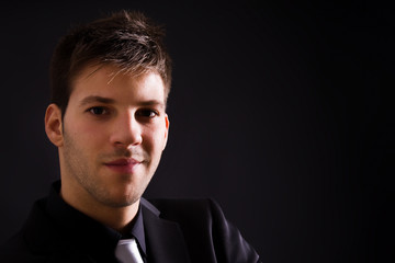 Obraz premium Close up portrait of a fashion young businessman black suit casu