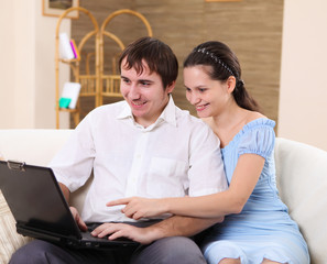 young family at home with a laptop