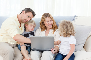 Fototapeta na wymiar Family looking at their laptop