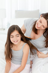 Woman brushing her daughter hair