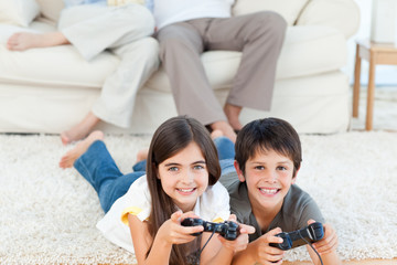 Children playing videogames while parents are talking