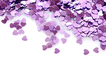 Violet hearts  in the form of confetti on white