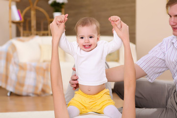 Fototapeta premium young family at home playing with a baby