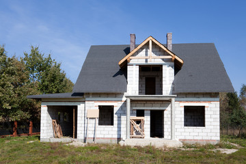 Fototapeta na wymiar Niedokończony dom z cegły z błękitnego nieba