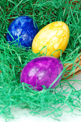 Drei bunte Ostereier im Ostergras