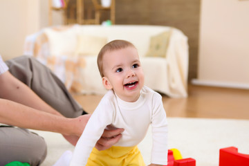 Fototapeta premium young family at home playing with a baby