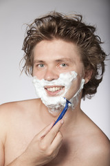 Attractive young man shaving