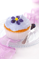 Closeup of cupcakes decorated with candied violets from flower o