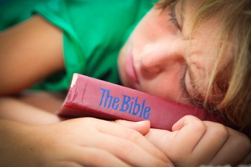 christian child sleeping with bible
