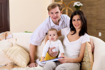 young family at home playing with a baby