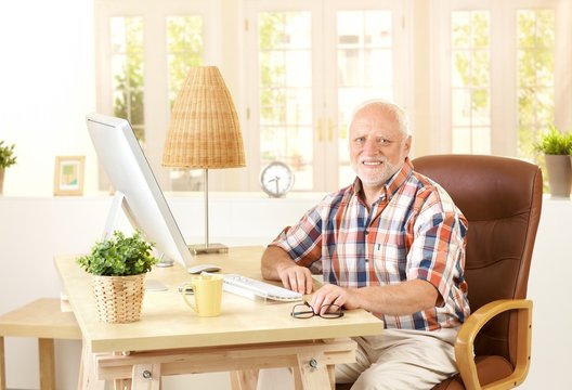Senior man sitting at desk at home