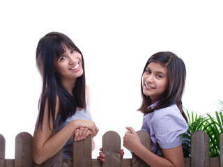 smiling teenage girls leaning on the fence