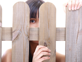 girl peeking through the fence