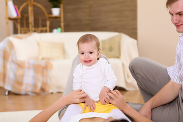 Fototapeta premium young family at home playing with a baby
