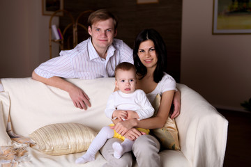 Fototapeta premium young family at home playing with a baby