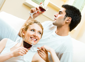 Obraz na płótnie Canvas Young happy amorous couple with redwine at home
