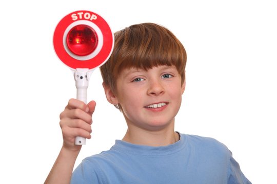 Junge zeigt Polizeikelle mit Stopzeichen