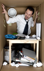 Man in the small office cardboard  box.