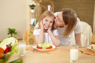 mother with teenager daughter having meal at home