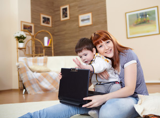 young woman and her son with a laptop at home