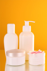 bottles of health and beauty products on yellow background