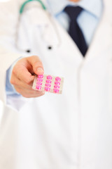 Doctors hand holding packs of pills. Close-up.