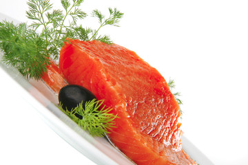 fresh smoked salmon on white plate with olives