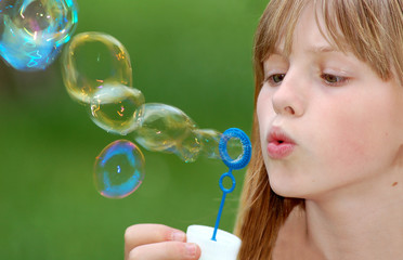 girl blows soap bubble