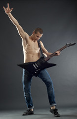 handsome guitarist making a rock gesture