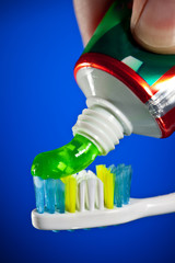 toothpaste being squeezed onto a toothbrush - obrazy, fototapety, plakaty