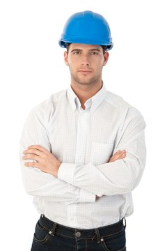 Goodlooking young architect standing arms crossed