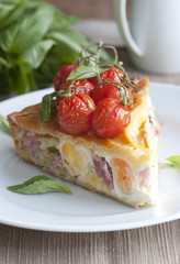 Bacon and egg pie with cherry tomatoes on top