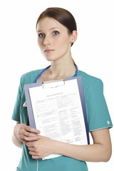 Feamle doctor wearing green uniform and holding a clipboard