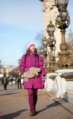 Obraz premium Happy tourist girl with funny bag in Paris on the Pont Alexandre