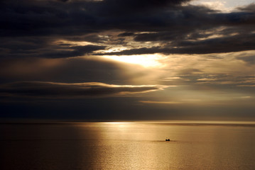 Lonely boat at sea by sunset