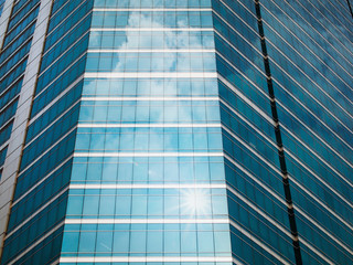 Glass of modern buildings and sky reflect