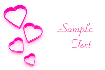 pink plastic pieces in heart shape isolated on white background