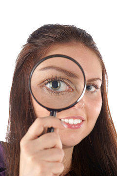Smiling girl looking through magnifying glass