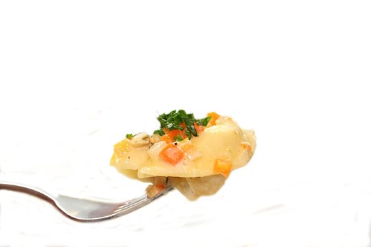 Tortellini mit Gem&uuml;sesauce auf einer Gabel