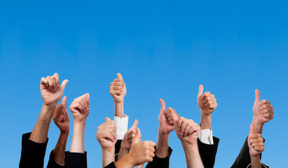 Multiracial Thumbs Up Against Blue Sky