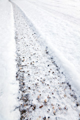 Fototapeta na wymiar Spuren von Winterreifen im Schnee