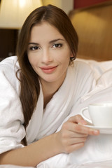 Closeup portrait of a happy young beautiful woman with a white c