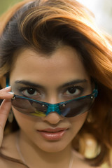 Exotic brunette looking over top of sunglasses