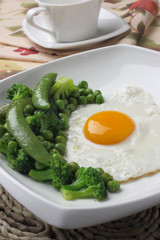 Fried egg with broccoli and green peas