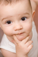 Fun caucasian baby with finger in his mouth