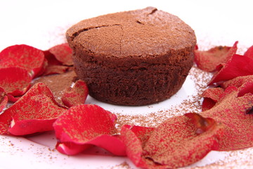 Chocolate soufflé decorated with rose petals and cocoa powder
