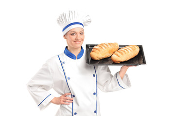 Smiling female baker showing freshly baked breads
