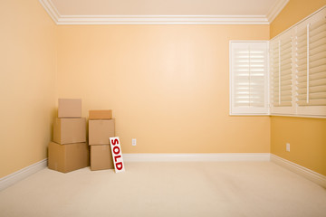 Moving Boxes and Sold Real Estate Sign on Floor