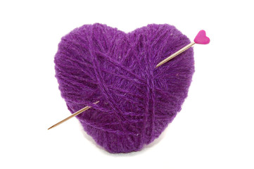 heart shape symbol made of wool pierced with a hearty needle