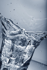 Fresh water splashing out of a glass with ice